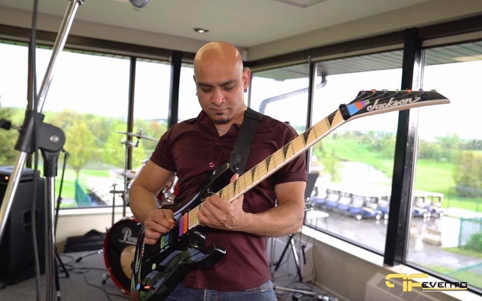 Guitarist playing in front of windows overlooking the golf course