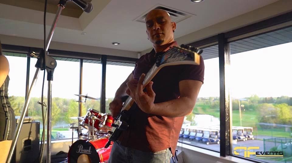 Guitarist in front of a red drum kit in the clubhouse lounge