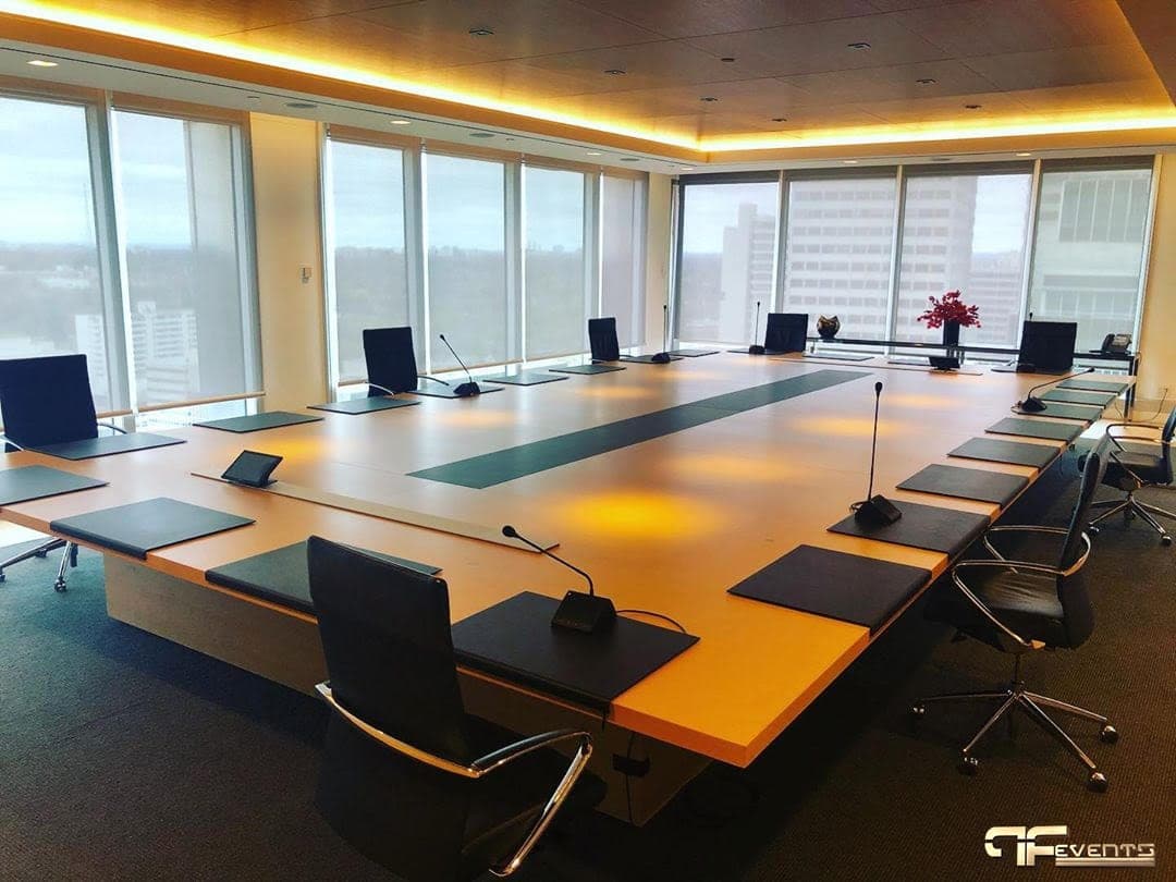 Boardroom table fitted with gooseneck delegate microphones at every seat