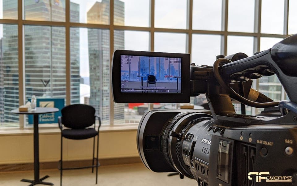 Sony XDCAM camcorder framing a high-top interview set against a city skyline